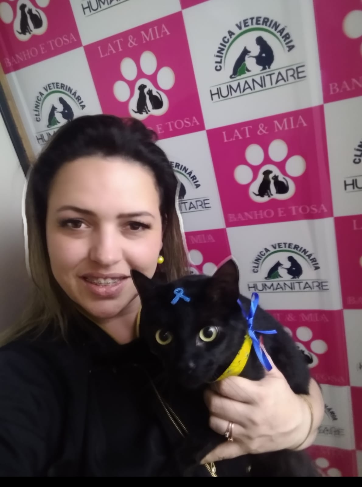 Integrante da Humanitare segura um gato preto